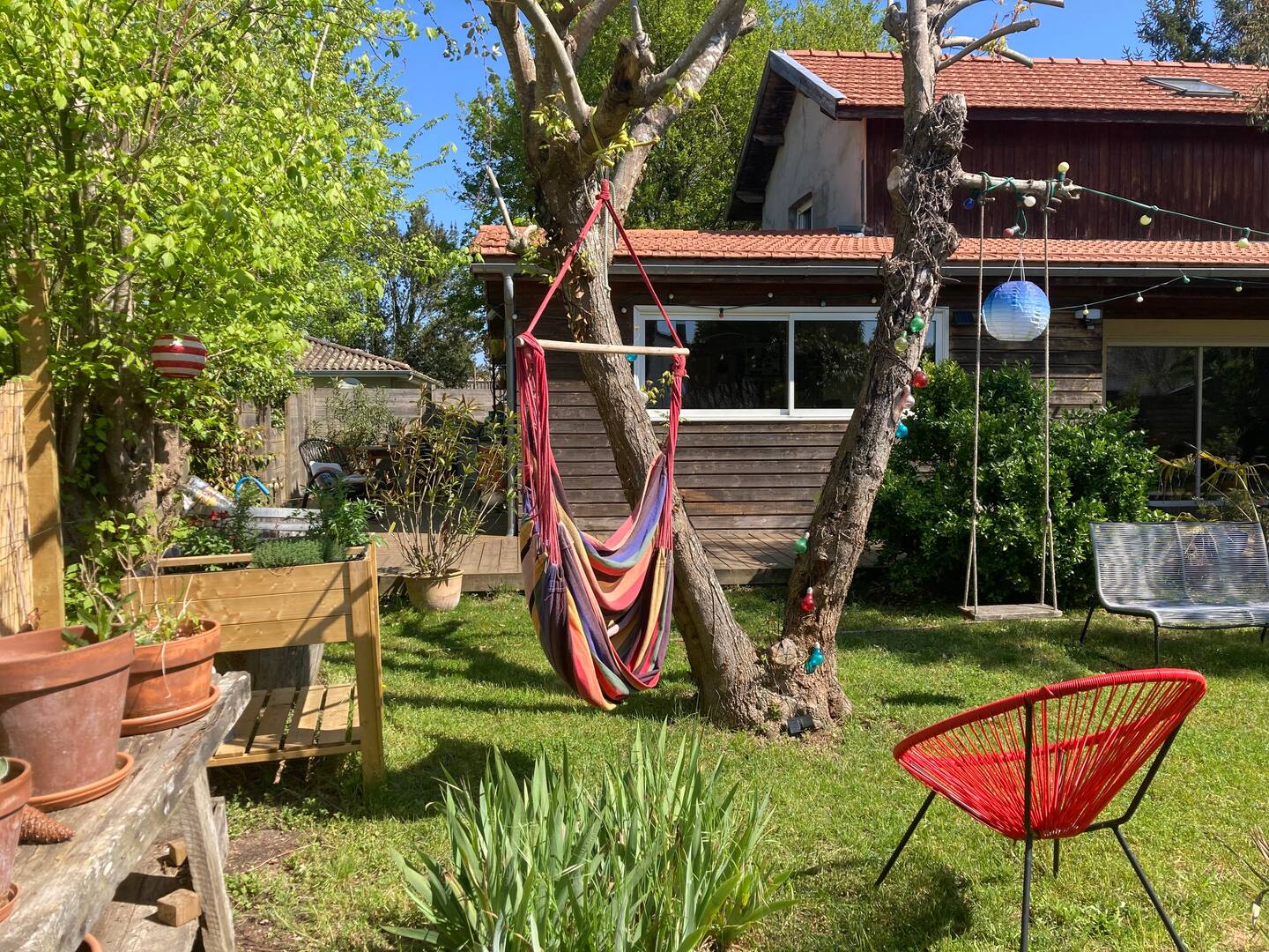 Balancelle et sièges de jardin vous attendent pour profiter de la nature.